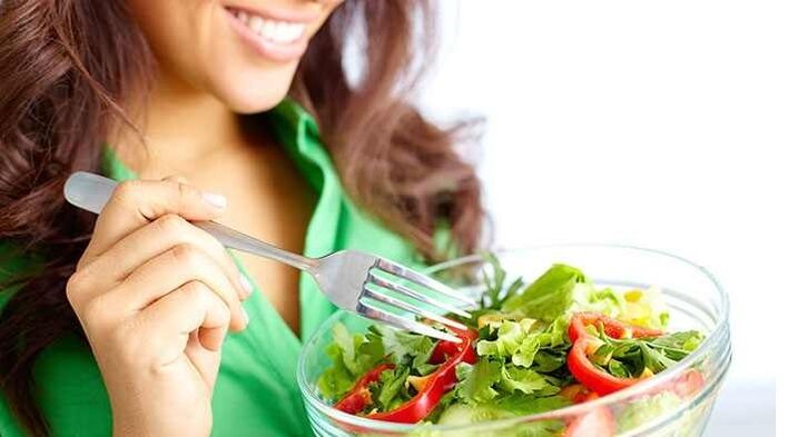 دختری که با رژیم پروتئینی سالاد سبزیجات می خورد